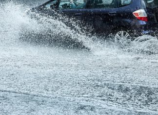 Car on flooded road during heavy rain
