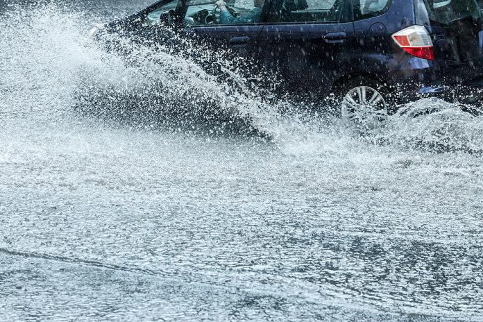 Car on flooded road during heavy rain