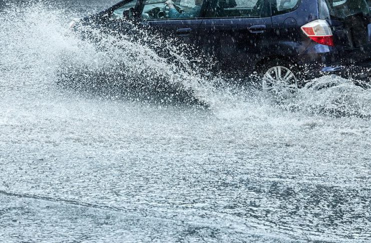 Car on flooded road during heavy rain