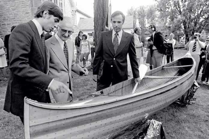 A 17-year-old Prince Andrew (left) receiving his handmade cedar-strip canoe from 70-year-old master builder Walter Walker (centre) in Lakefield on June 15, 1977. On the right is Terry Guest, headmaster of Lakefield College School which Prince Andrew attended from January to June in 1977. Prince Andrew donated the canoe  to The Canadian Canoe Museum's collection in 2004. (Photo: Michael Peake)