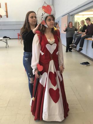 Miranda Steiginga helping  Tori Thibodeau with her costume as The Queen of Hearts during a rehearsal of  "Alice @ Wonderland: The Musical". (Photo:  Jim Mills)