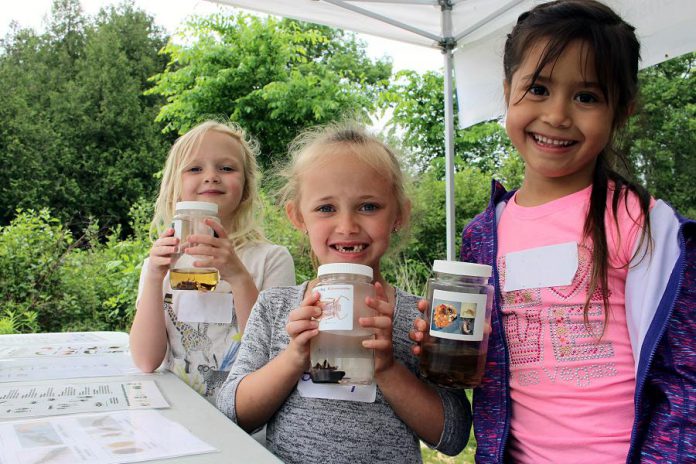 Students attending the 2018 Peterborough Children's Water Festival hold up their favourite invertebrates. The Otonabee Conservation activity centre allowed children to get up close with many aquatic bugs and insects to understand how their unique features allow them to live in water. Last year's festival had registration numbers, prompting the festival's steering committee to add a third day in 2019. (Photo: Karen Halley / GreenUP)