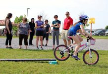 A Grade 5 student from Monsignor O'Donahue Catholic Elementary School demonstrates her riding skills on the Bike Playground, while funders and partners of the Pedal Power program look on. (Photo: Karen Halley)