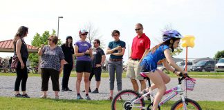 A Grade 5 student from Monsignor O'Donahue Catholic Elementary School demonstrates her riding skills on the Bike Playground, while funders and partners of the Pedal Power program look on. (Photo: Karen Halley)
