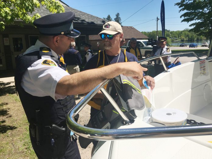 Leigh Mellow (right), past commander (2013 to 2016) of the Peterborough Power and Sail Squadron and its current communications officer, discusses on-water safety with Peterborough OPP Staff Sergeant Chris Galeazza during an event marking the 60th anniversary of the squadron’s 1959 founding.  (Photo: Paul Rellinger / kawarthaNOW)