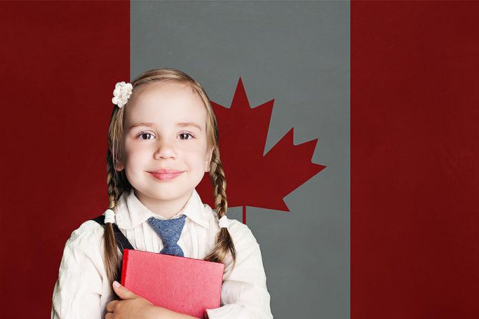 A young female student in front of the Canadian flag