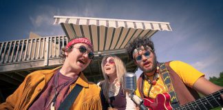 In Beau Dixon's "Bloom: A Rock 'n' Roll Fable", Owen Stahn (left) is Neph Burnstall and Eli Tanner (right) is Griffin Clark, two childhood friends who grow up to form the 1960s Canadian rock 'n' roll band The Spruce Street Ramblers, which rises to fame only after Tess Wilson (played by Kate Suhr, centre) joins the band. Directed by Kim Blackwell, the play runs every Tuesday to Saturday at 4th Line Theatre in Millbrook until July 27, 2019. (Photo: Wayne Eardley / Brookside Studio)