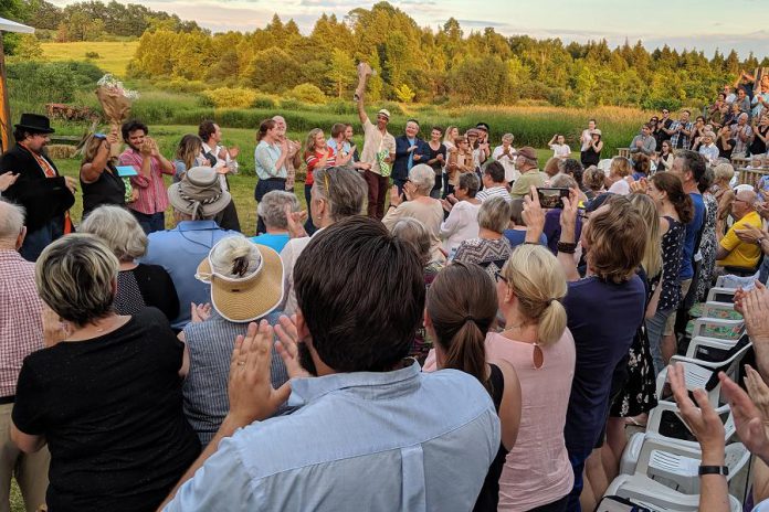 The cast and crew of "Bloom: A Rock 'n' Roll Fable" during a standing ovation after the performance of "Bloom: A Rock 'n' Roll Fable" at 4th Line Theatre in Millbrook on opening night on July 4, 2019. Director Kim Blackwell and playwright Beau Dixon are holding up bouquets of flowers they were gifted in recognition of the play's success.  Photo: Bruce Head / kawarthaNOW.com)