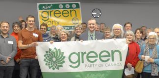 Brock Grills, pictured here (under clock, holding banner) after winning the Peterborough-Kawartha federal Green Party nomination on February 25, 2019, has stepped down as the candidate for personal reasons. (Photo: Peterborough-Kawartha Federal Green Party Association )