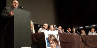 As panel members look on and with photographs of overdose victims displayed on stage, Ontario Associate Minister of Health and Addictions Michael Tibollo speaks at the Opioid Summit on July 11, 2019 at Market Hall Performing Arts Centre in downtown Peterborough. The summit was jointly organized and hosted by Peterborough Mayor Diane Therrien and Selwyn Deputy-Mayor Sherry Senis. (Photo: Office of Michael Tibollo / Twitter)