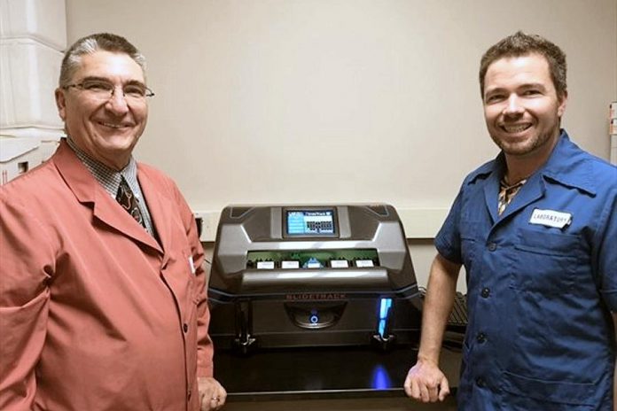 PRHC laboratory manager at Peterborough Regional Health Centre and Lab Improvements CEO Alex Bushell with SlideTrack, the new benchtop automated slide sorting and filing machine that is the first of its kind in the world. (Photo: PRHC)