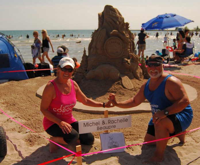 Master sculptors Michel Beaupre and Rachelle Rocheleau from Quebec pose in front of their sculpture at the Cobourg Sandcastle Festival on August 3, 2019. (Photo: April Potter / kawartha