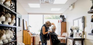 From the Neck Up owner Frances Fourcaudot working on a client at her boutique in the Westmount Pharmacy building in Peterborough. Frances is a hair loss and trichology (hair and scalp health) specialist who offers a selection of full and partial custom-styled human hair wigs, synthetic wigs, and hair toppers, as well as wig repairs, for women, men, and children who experience temporary or permanent hair loss. (Photo: Heather Doughty)