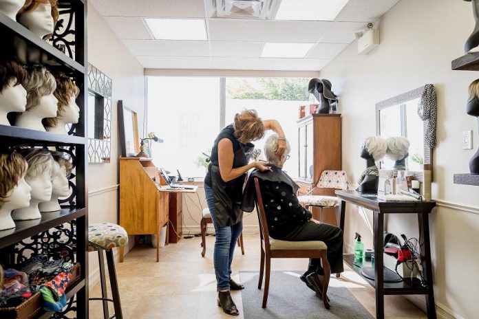 From the Neck Up owner Frances Fourcaudot working on a client at her boutique in the Westmount Pharmacy building in Peterborough. Frances is a hair loss and trichology (hair and scalp health) specialist who offers a selection of full and partial custom-styled human hair wigs, synthetic wigs, and hair toppers, as well as wig repairs, for women, men, and children who experience temporary or permanent hair loss. (Photo: Heather Doughty)