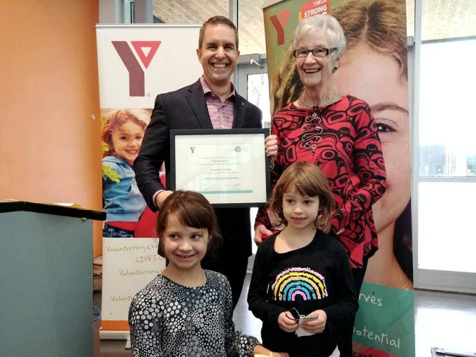 YMCA of Central East Ontario board chair John Mastorakos presents Peterborough educator and activitist Rosmary Ganley with the 2018 YMCA Peace Medal on November 23, 2018 as Ganley's grandaughters Ava and Emma look on. Nominations for the 2019 Peace Medal are now open. (Photo: YMCA of Central East Ontario / Facebook)