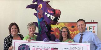 Pterborough Regional Health Centre (PRHC) Foundation president and CEO Lesley Heighway (left) and PRHC Foundation board chair Gord McFarland (right) accept a cheque for $241,738.54 from incoming Peterborough's Dragon Boat Festival chair Gina Lee, festival dragon Bill Thornton (in costume), and outgoing festival chair Michelle Thornton on September 18, 2019 at PRHC. (Photo courtesy of Peterborough's Dragon Boat Festival)