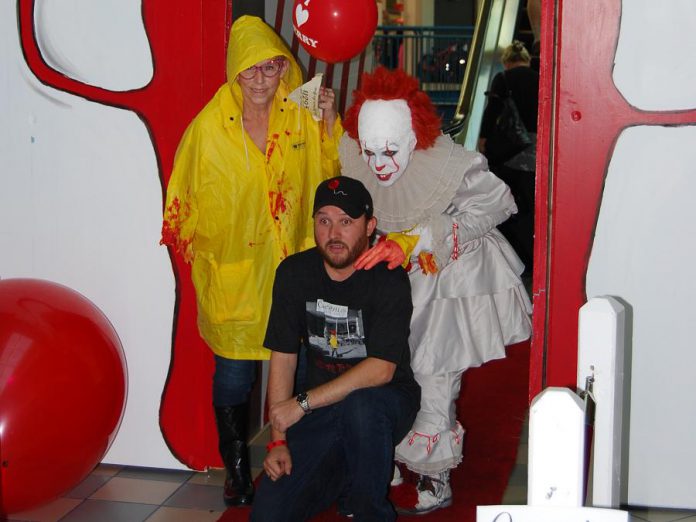 Adam Pearson, owner of Queenies Bake Shop, at a special screening of "IT Chapter Two" at Cobourg's Rainbow Cinemas in Northumberland Mall on September 5, 2019, along with costumed fans Laurie Statt and Melindah Knott. Pearson, with the help of local artists and volunteers, created a large-scale art project for the screening which also raised funds for the Northumberland Fare Share Food Bank. Pearson, whose Port Hope business benefited from the production of the film, appears as an extra who get shoved out of the way by actor James McAvoy during the film's funhouse scene. (Photo: April Potter / kawarthaNOW.com)