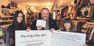 Terry Guiel, executive director of the Peterborough Downtown Business Improvement Area (DBIA), and Wendy Gillis and Malissa Almond hold up a giant Holiday Shopping Passport as they celebrate the launch of the annual downtown shopping program on November 12, 2019 at Save Our Soles (385 George St. N., Peterborough), one of the 148 businesses and organizations in downtown Peterborough participating in the program. Shoppers get a stamp every time they spend $10 at one of the participating locations, and completed passports are entered into a draw for "downtown money" that can be redeemed at participating locations. (Photo courtesy of Peterborough DBIA)