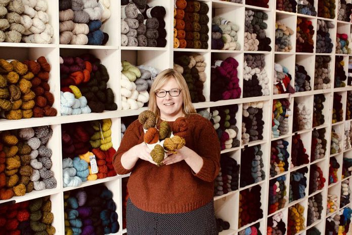 Owner Deanna Guttman in front of the wall of yarn at Needles in the Hay in downtown Peterborough, which is one of only a handful of stockists in Canada that carry the famous Brooklyn Tweed line. Needles in the Hay is launching BT by Brooklyn Tweed, two quick and fun patterns, written with the beginner knitter in mind. Great projects for gift giving, and free with with yarn purchase, they're only available until December 4th. (Photo: Amy E. LeClair)