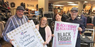 Peterborough Downtown Business Improvement Area (DBIA) executive director Terry Guiel and marketing committee member Julie Morris with Gail and John Martin, owners of John Roberts Clothiers, one of 100 downtown businesses participating in Black Friday and the Holiday Shopping Passport program, where you can win prizes by choosing local first for your holiday shopping. (Photo courtesy of Peterborough DBIA)