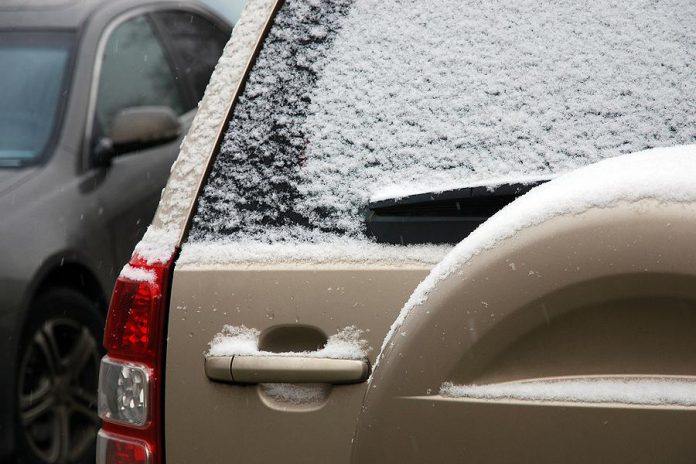 Car window covered with light snow