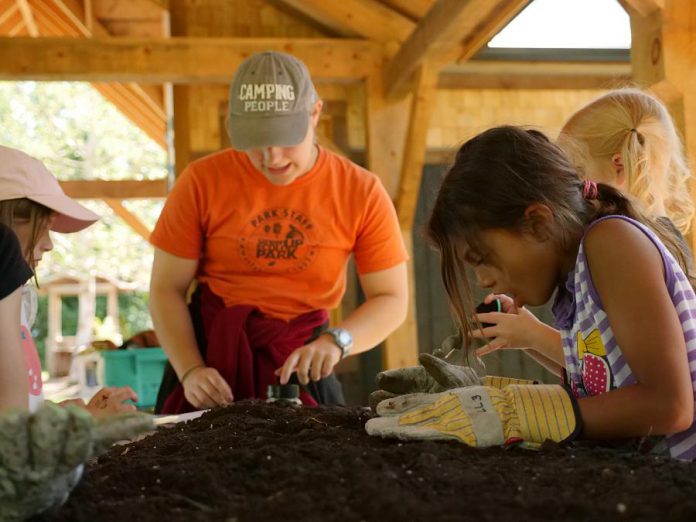 Participants in the Earth Adventures summer camp conduct a soil study within the new open-air classroom that was built in 2018 thanks to donations to GreenUP. Funds raised this holiday season will be used to install solar panels and lighting on this building, amongst other projects.  (Photo courtesy of GreenUP)