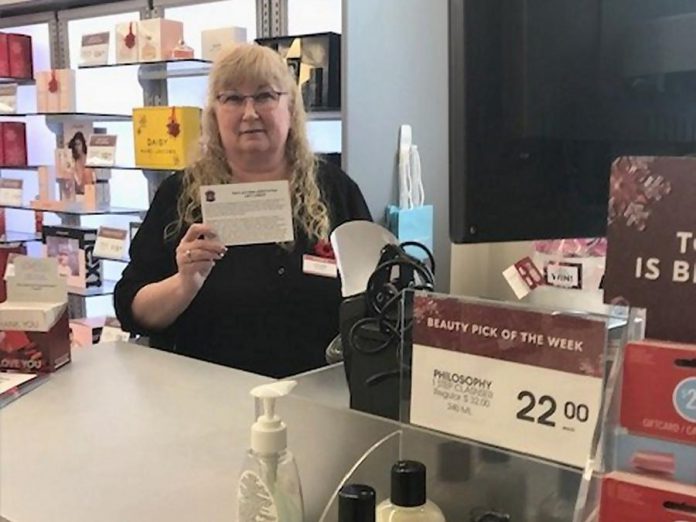 An employee at Shoppers Drug Mart displays a fraud prevention card, supplied by the Kawartha Lakes Police Service, that retailers can share with customers who are at risk of falling victim to the gift card scam. (Supplied photo)