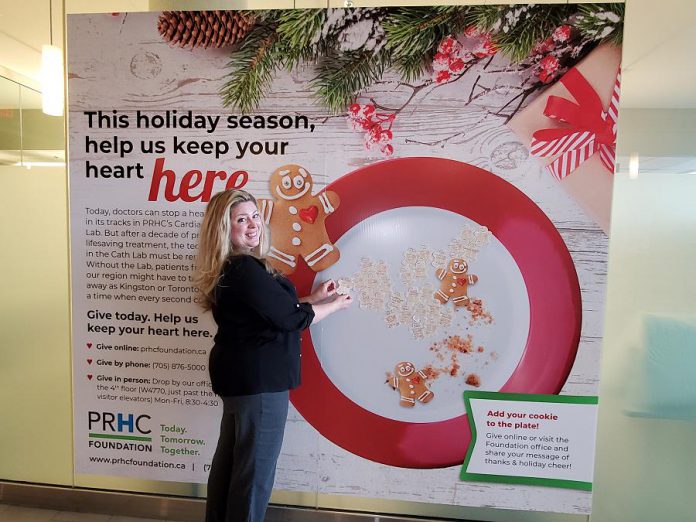 Meghan Moloney, Charitable Giving Advisor with the Peterborough Regional Health Centre (PRHC) Foundation, adds a Grateful Hearts cookie tribute featuring a message of thanks to the PRHC Foundation's "big plate" holiday display in the hospital's main lobby. By making a donation to the PRHC Foundation this holiday season, you can not only share your message or holiday greetings with doctors, nurses, and staff of our regional hospital, but your donation will help to fund needed new equipment and technology at the hospital's Cardiac Catheterization Lab, which provides life-saving care to thousands of people every year. (Photo courtesy of PRHC Foundation)