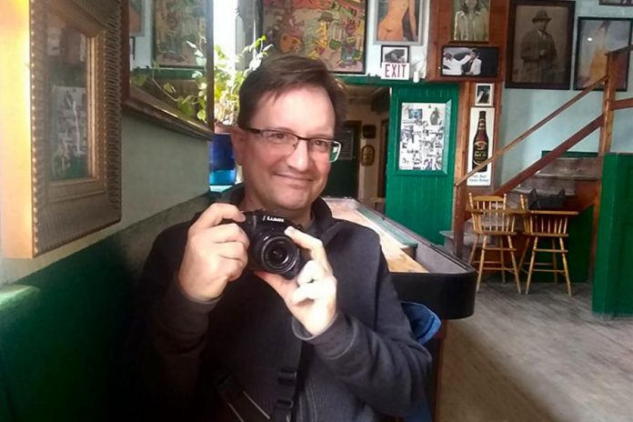 A rare photo of Peterborough photographer Andy Carroll, taken at The Only in downtown Peterborough. Preferring to stay behind his lens, Andy has quietly created an ongoing visual documentation of Peterborough's landscapes and culture, with a focus on theatre and music. (Photo: Sam Tweedle / kawarthaNOW.com)