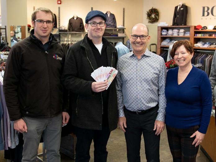 The Peterborough Downtown Business Improvement Area (DBIA) annual Holiday Shopping Passport program rewards people when they shop, dine, or treat themselves in downtown Peterborough. Kevin Dawe of Peterborough (second from left) picked up his prize of $500 in "downtown money" at John Roberts Clothiers, one of more than 150 businesses and organizations partipcating in this year's Holiday Shopping Passport program. Also pictured are Peterborough DBIA communications manager Joel Wiebe and John Roberts Clothiers owners John and Gail Martin. There are two more early bird draws for $500 in December and a grand prize draw of $1,500 in January. (Photo courtesy of Peterborough DBIA)