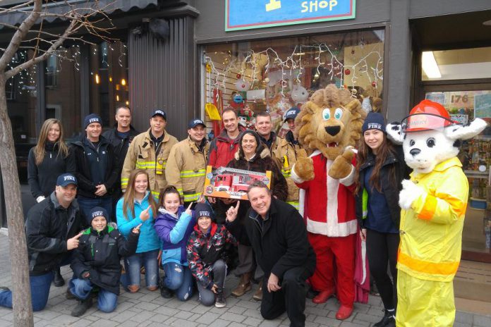 The Peterborough Professional Firefighters are donating $2,000 to The Toy Shop in downtown Peterborough so owner Jean Grant can use the funds to n to leverage deals for more than $6,000 worth of toys from her suppliers, who help with the initiative. The toys will be donated to the annual Salvation Army Toy Drive. (Photo courtesy of Peterborough DBIA)
