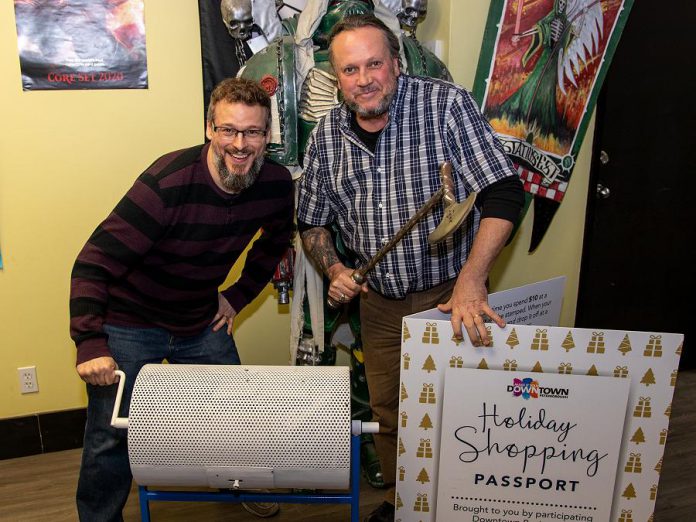 The Holiday Shopping Passport program is an annual initiative by the Peterborough Downtown Business Improvement Area (DBIA) to encourage people to choose local. During the 2019 Holiday Shopping Passport Program, Downtown shoppers stamped approximately $2.3 million in downtown purchases on their passports. Pictured are DBIA executive director Terry Guiel and Dueling Grounds owner Wayne Mittlestead drawing the winning Holiday Shopping Passport, belonging to Karen Procyk of Peterborough. (Photo courtesy of Peterborough DBIA)