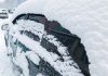 Car covered in snow in winter after blizzard