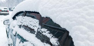 Car covered in snow in winter after blizzard