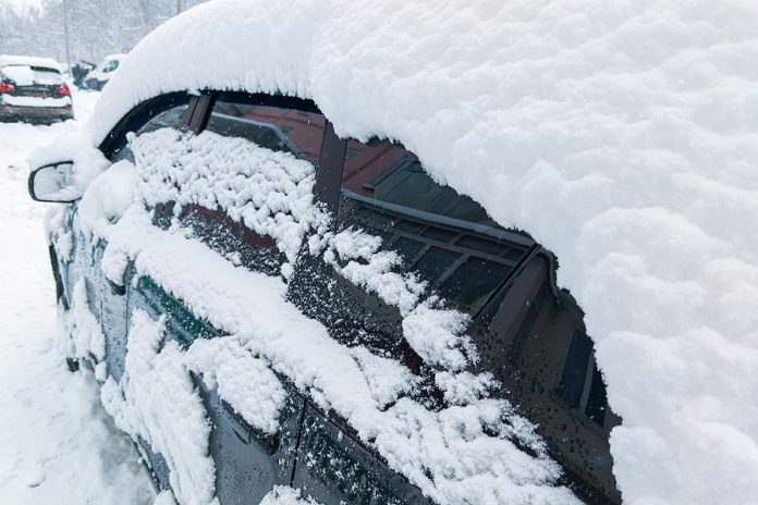 Car covered in snow in winter after blizzard