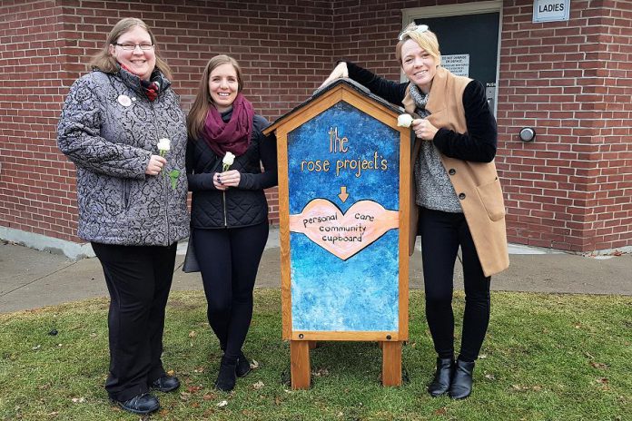 Founder Rose Wilton (left) with The Rose Project's personal care community cupboard, located behind Port Hope's Town Hall with the approval of the municipality. Designed and built out of donated materials by Courtney Sutton (middle) of Northern Revival Co., with the artwork on the back of the cupboard (pictured) created by Lee Higginson (right) of Fluke Craft, the cupboard is stocked with items such as soap, toothbrushes and toothpaste, feminine hygiene products, toilet paper, and more. The goal of the cupboard is to give people who are homeless or financially struggling access to personal care items they might not otherwise be able to afford, helping them to stay clean and healthy while allowing them to maintain their dignity. (Photo courtesy of The Rose Project)