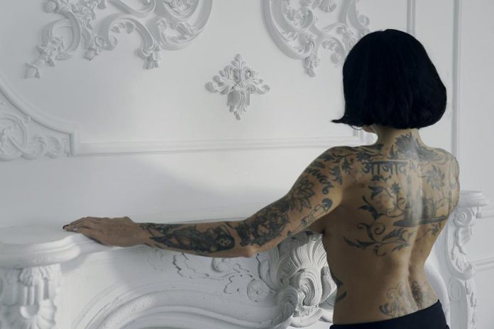 Bif Naked is heavily tattooed, getting her first tattoo (an Egyptian Eye of Horus) when she was 16. Her tattoos include a symbol of the Tao, Japanese writing, Buddhist poetry and images, and Hindu imagery. Her favourite tattoo, on her left arm, reads "Survivor".   (Photo: Coco & Kensington Photography)