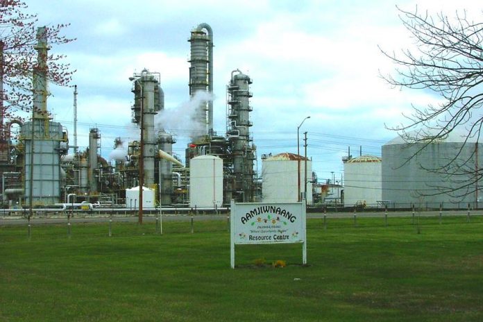 Aamjiwnaang First Nation is located in the heart of Sarnia's Chemical Valley. Pictured is the front yard of the Aajimwnaang Resource Centre in 2012 adjoining a Dow Chemical plant. (Photo: TheKurgan / Wikipedia)