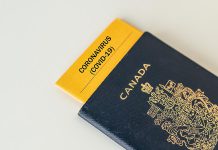 A Canadian passport with a COVID-19 pamphlet inserted inside of it
