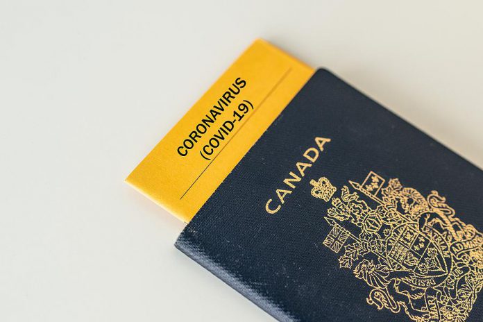 A Canadian passport with a COVID-19 pamphlet inserted inside of it