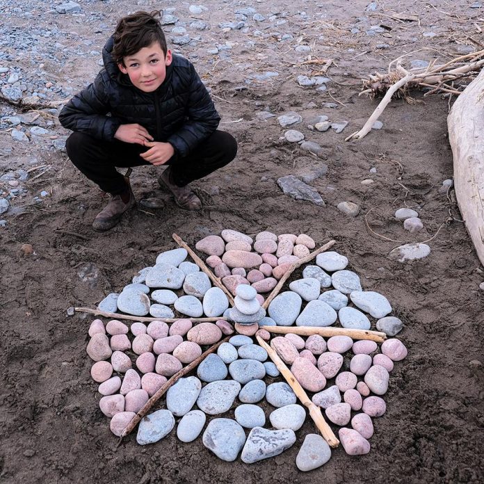 Port Hope artist Lee Higginson's son Sam with his creation at West Beach in Port Hope. Lee and her sons Sam and Charley, who are both young artists, hope to make as much public art as they can during the COVID-19 shutdown. (Photo courtesy of Lee Higginson)