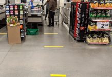 Many grocery stores have already placed a limit on the maximum number of items of any one product that a customer can buy and have dedicated their first hour of operation to serving seniors and those with disabilities. Stores have begun to place floor markers at check-out lines to remind customers of the recommendation for two metres of social distancing and some are installing plexiglass shields for the checkout counters. The Loblaw Real Canadian Superstore at Lansdowne Place in Peterborough has installed social-distancing floor markers at staggered check-out lines, and each customer must wait at a safe distance until the customer ahead of them has completed packing their own groceries. (Photo: Bruce Head / kawarthaNOW.com)