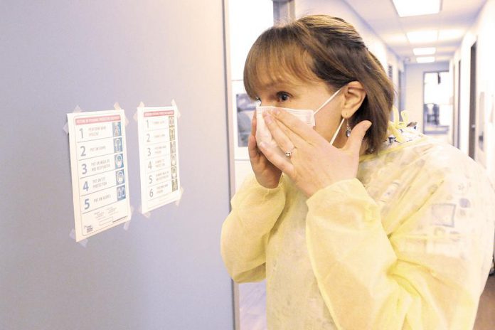 Public health nurse Julie Brandsma dons a mask as she prepares to test a patient for COVID-19. (Photo courtesy of Peterborough Public Health)