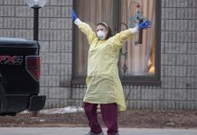 A health care worker at Pinecrest Nursing Home in Bobcaygeon, Ontario responds to passing cars honking support on Tuesday, March 31, 2020. (Photo: Fred Thornhill / The Canadian Press)