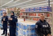 Police officers at an unidentified location in Canada protect a skid of toilet paper. Could this become a common sight in Canada under the proposed "Protection Of Our Paper" (POOP) Act? (Photo source: jkooshan / reddit.com)
