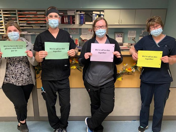 Team members from the medical north unit at Ross Memorial Hospital in Lindsay with messages for the community: "We're here for you, please stay home for us." and "We're all in this together."  (Photo courtesy of Ross Memorial Hospital)