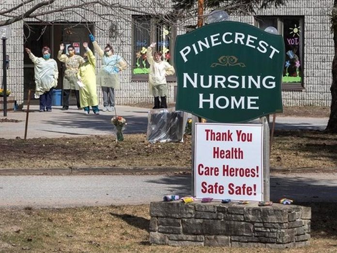 Healthcare workers at Pinecrest Nursing Home in Bobcaygeon wave as passing cars honk support on April 1, 2020. (Photo: Fred Thornhill / The Canadian Press)