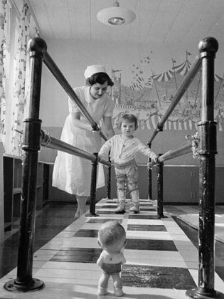 A physiotherapist with a young polio patient in at the walking bars in the polio clinic at Sudbury General Hospital in March 1953. (Photo: Canadian Public Health Association)