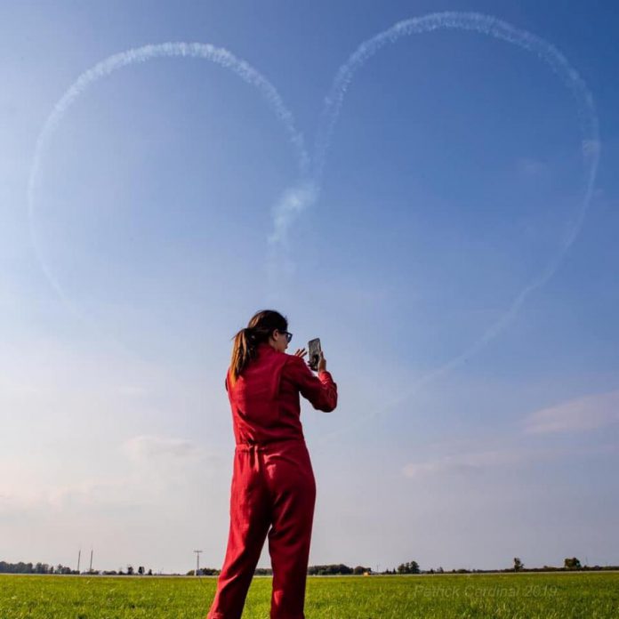 Captain Jennifer Casey taking a photo of a heart created by the Canadian Forces Snowbirds. (Photo: Patrick Cardinal / Snowbirds)