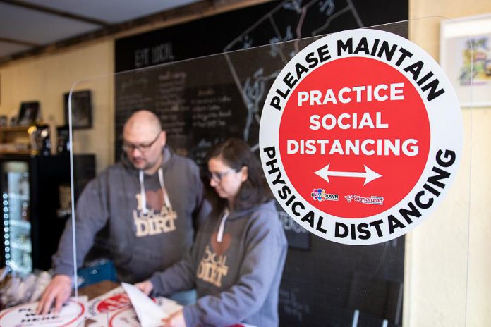 A vinyl graphic encouraging physical distancing is displayed in the window of The Food Shop on Water Street in downtown Peterborough. It's part of a COVID-19 retail kit available to members and associate members of the Peterborough Downtown Business Improvement Area (DBIA), thanks to a partnership between the DBIA and Signarama Peterborough. (Photo courtesy of Peterborough DBIA)